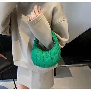 Model showing green quilted puffer handbag in light nylon with stylish square pattern