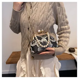 Detail of vintage floral shell bag with large pearl clasp and bead chain strap