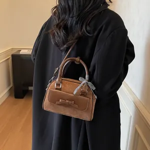 Bolso de mano retro de gamuza marrón con lazo de cuero y bufanda a cuadros como bandolera