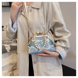 Detail of light blue floral embroidery on vintage shell bag with pearl chain handle