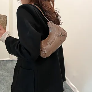 Bolso media luna retro marrón con textura arrugada y detalles de hebilla plateada