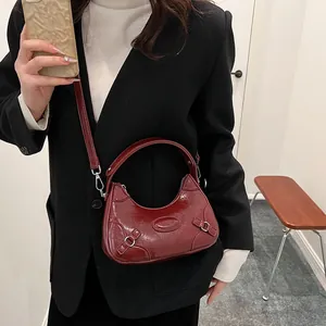 Elegante bolso de media luna burdeos con acabado brillante y logotipo para otoño de 2025