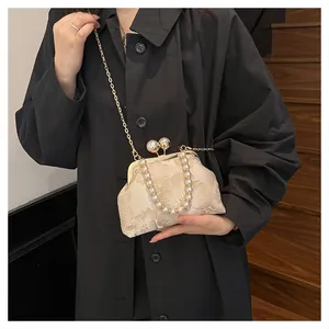 Detail of floral jacquard shell bag with oversized faux pearl handle and metal clasp