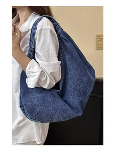 Retro denim tote bag worn over the shoulder showing large capacity and soft texture