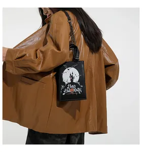 Detail of Halloween magic book handbag with metallic chain strap worn over the shoulder