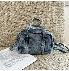 Detailed view of washed denim handbag with dual handles and adjustable shoulder strap