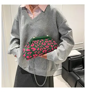 Detalle del bolso de punto verde con estampado de leopardo rosa y cadena de metal plateado