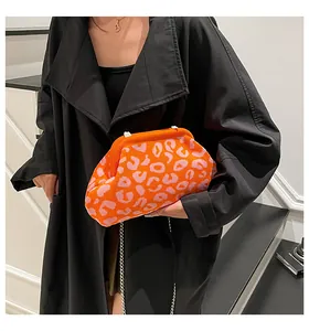 Primer plano del bolso nube de punto con estampado de leopardo naranja y rosa y cadena