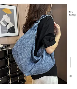 Detail of a large denim tote bag featuring vintage washed canvas material and spacious design