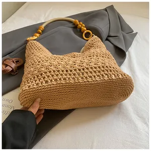 Detailed close-up of handmade woven tote bag featuring unique wooden bead handle and texture
