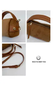 Detalle del bolso cilíndrico de ante marrón con tachuelas doradas y flecos de cuero