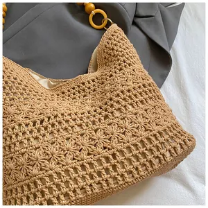 Detailed macro view of woven tote bag showing floral crochet patterns and wooden beads
