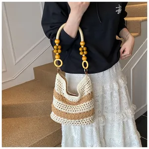 Detail of hand-woven tote bag showing striped crochet patterns and beaded handles