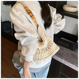 Detail of hand-crocheted floral tote bag with oversized wooden beads on shoulder strap