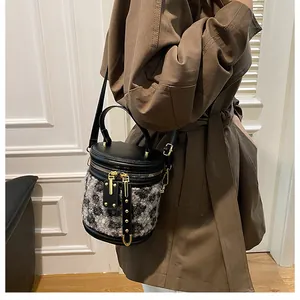 Detalle de bolso bucket de pelo sintético con estampado de leopardo y cuero negro