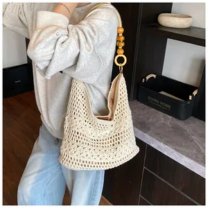 Detail of bohemian hollow-out crochet tote with natural wood bead handle and inner lining