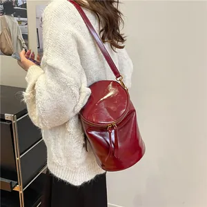 Bolso cubo cilíndrico en cuero rojo profundo brillante para un look de otoño elegante