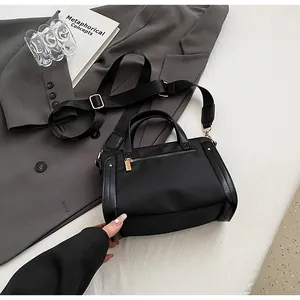 Detalle del bolso tote de nailon con herrajes dorados y correa ancha ajustable