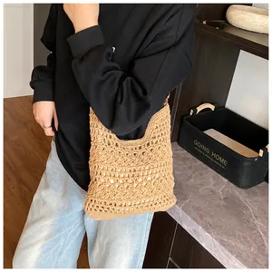 Detail of light brown crochet tote with hollow pattern and gold metal ring buckle