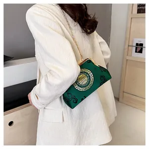 Detail of green satin chain bag with golden Longevity embroidery and vintage metal clasp