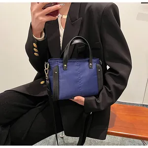 Detalle del bolso tote de nailon azul marino con ribetes de cuero y correa ancha