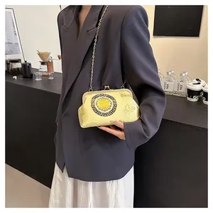 Detail of a retro Chinese yellow silk chain bag with traditional cloud patterns