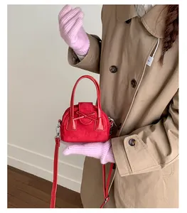 Detalle de mini bolso rojo con lazo mostrando texturas de ante mate y cuero liso