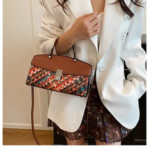 Détail du sac tissé coloré avec rabat en cuir marron et fermoir métallique argenté brillant