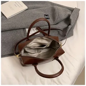Vue détaillée du sac Boston marron foncé avec doublure grise et poche zippée