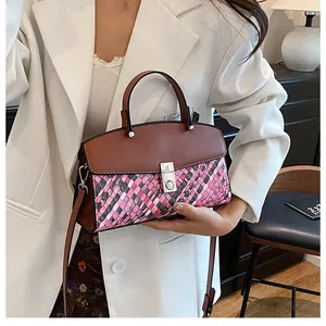 Détail du sac à bandoulière tissé avec fermoir argenté et bandoulière marron réglable