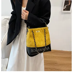 Bolso tipo cubo amarillo acolchado con correa de cadena y logo Bowen Nova en modelo