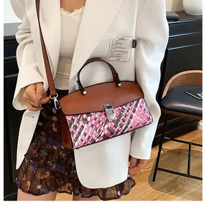 Détail d'un sac à main tissé en patchwork avec rabat en cuir brun et fermoir rotatif