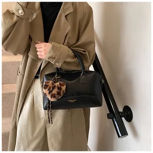 Détail du sac à main Boston noir avec cuir texturé et breloque cœur imprimé léopard
