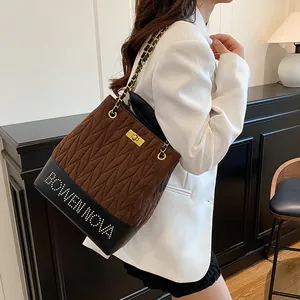 Bolso saco acolchado marrón con cadena dorada y detalles de tachuelas para mujer