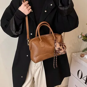 Sac à main vintage marron en cuir avec pompon léopard et bandoulière amovible