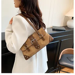 Details einer braunen Vintage-Schultertasche mit silberner Schnalle und Metallnieten