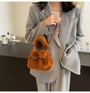 Detail of caramel faux fur handbag with bow ornament and leather shoulder strap