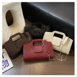 Detalle de cuatro bolsos tote de cuero sintético con textura de piedra y cadena
