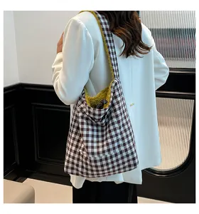 Detalle de bolso tote a cuadros con forro polar amarillo y correa de hombro