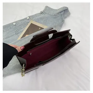 Interior view of burgundy tote bag with stone pattern, chain strap, and inner pockets