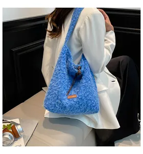 Detalle del bolso tote de peluche azul con etiqueta Star Picking naranja y cordón ajustable
