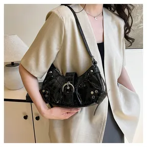 Detalle de bolso de hombro negro con efecto cocodrilo y hebilla plateada