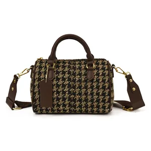 Classic houndstooth boston bag with brown handles and gold hardware on white background