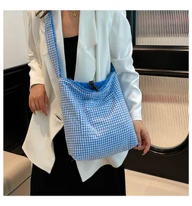 Detalle de bolso tote de lona a cuadros azules con forro de lana y bolsillo frontal