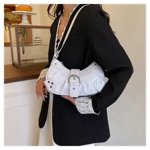 Detalle de bolso de hombro blanco con textura de cocodrilo, hebillas y tachuelas