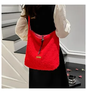 Detalle de bolso tote de felpa roja con forro de cuadros y cierre de cordón