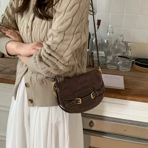 Bolso tipo montura retro marrón con monograma, hebilla dorada y correa de bandolera