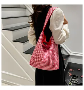 Detalle del bolso tote de cuadros rojos y blancos con gran capacidad y tejido de algodón