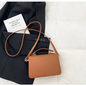 Détail de la texture litchi caramel sur le sac à main avec ferrures dorées