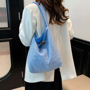 Bolso tote de cuadros azules y blancos con forro de felpa mostrado en una modelo
